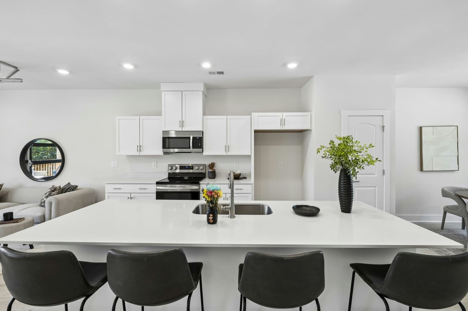 Kitchen with a long white island seating four.