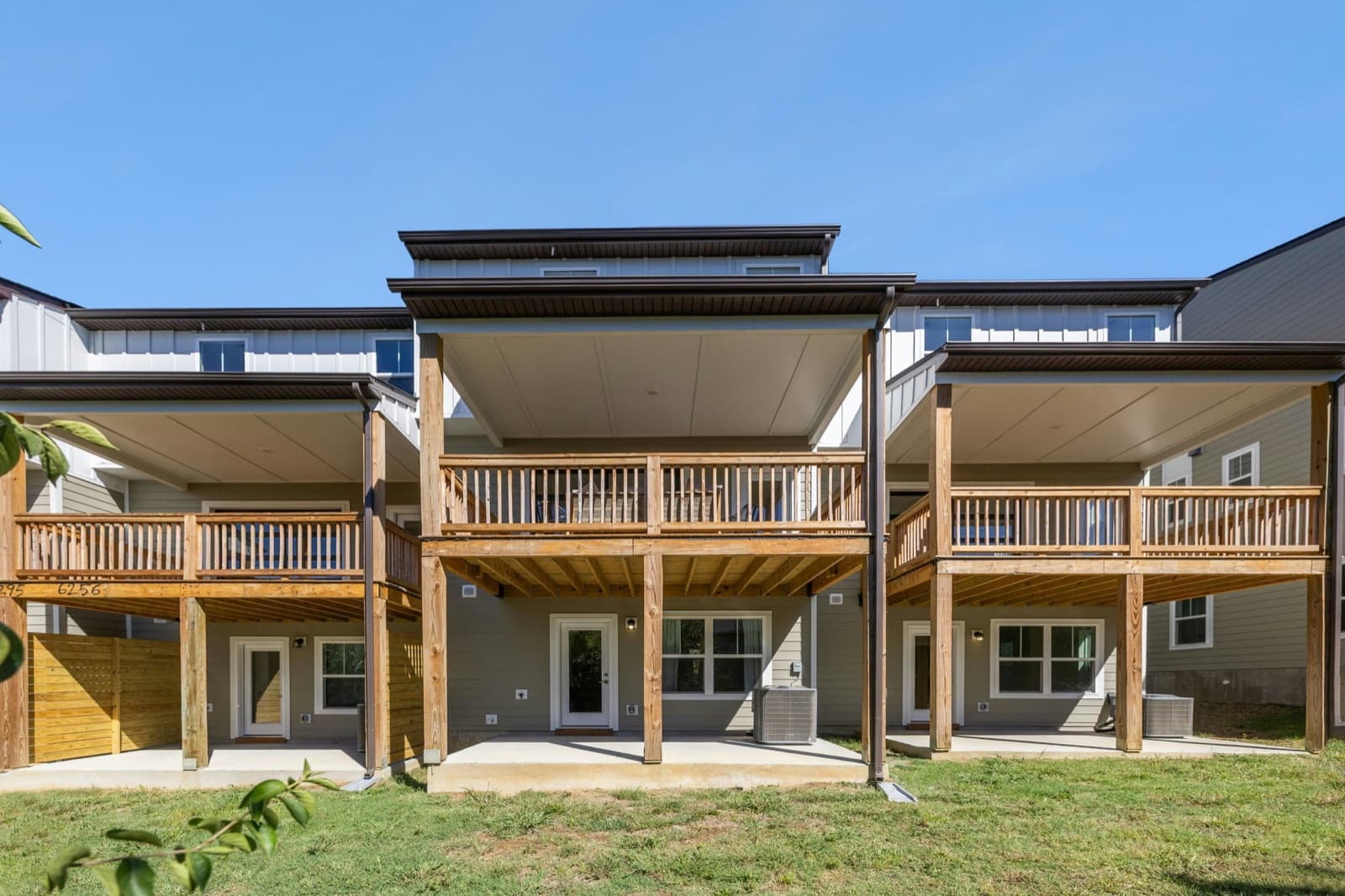 Rear of the townhomes showing covered decks above covered patios.