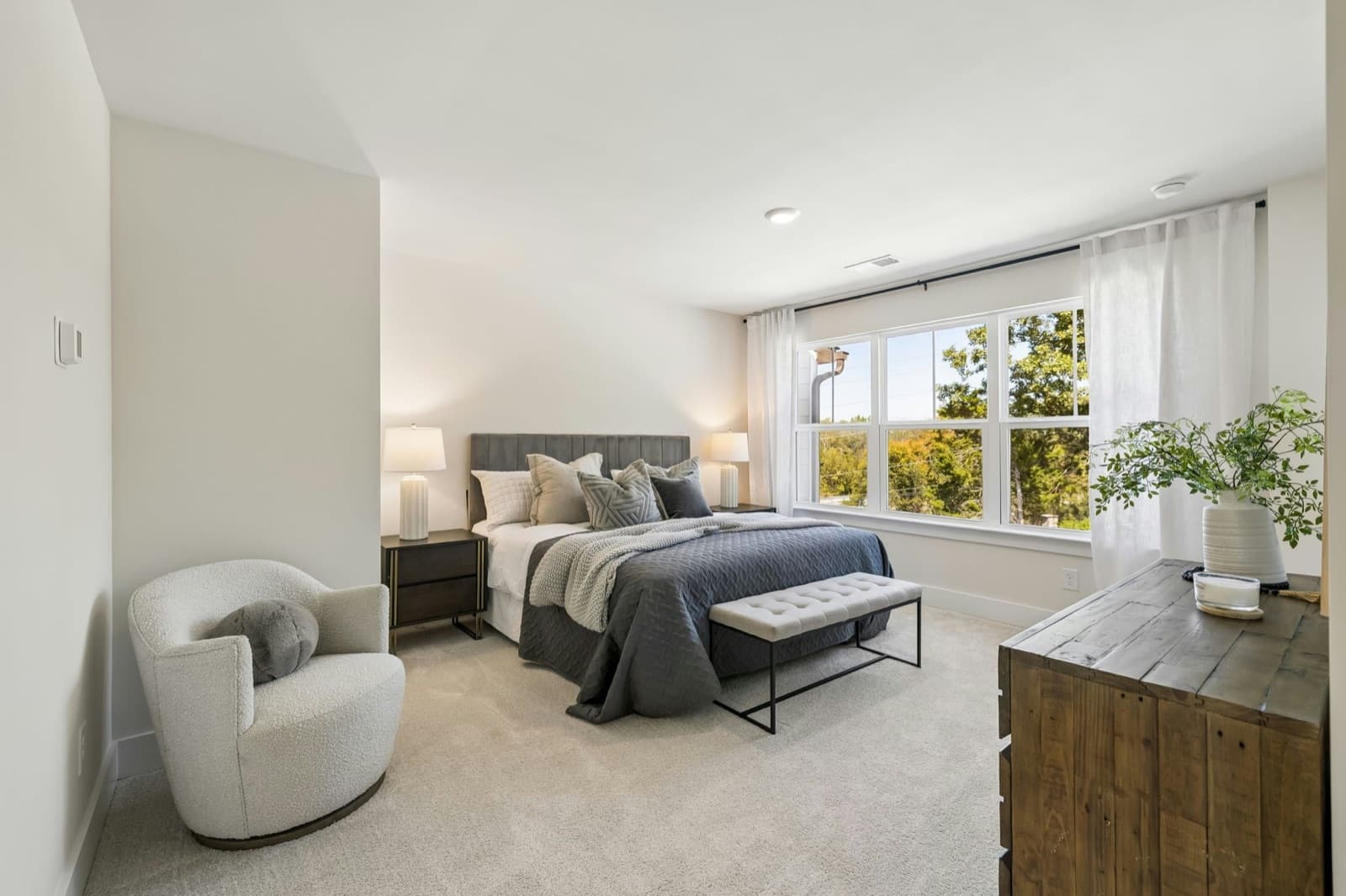 Upstairs bedroom with a triple window onto treetops.